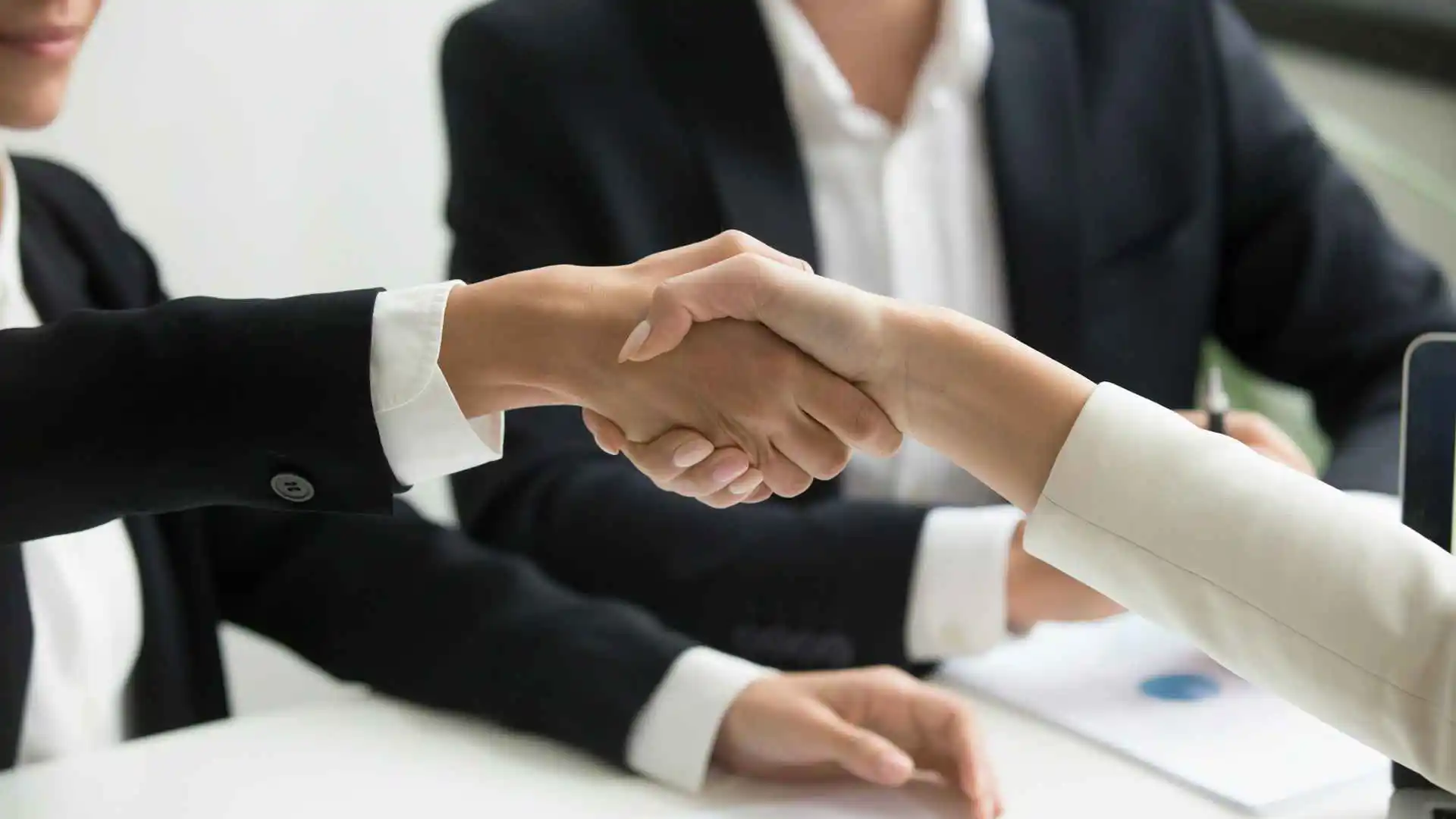 Due persone che si stringono la mano in un ufficio